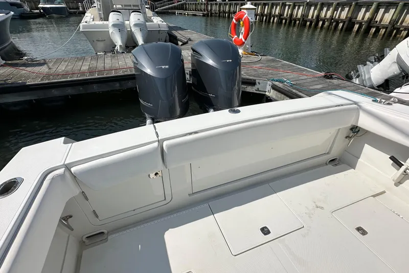 Slide: The Image of 2010 Jupiter 34 FS boat with dual outboard engines docked at marina. - 56