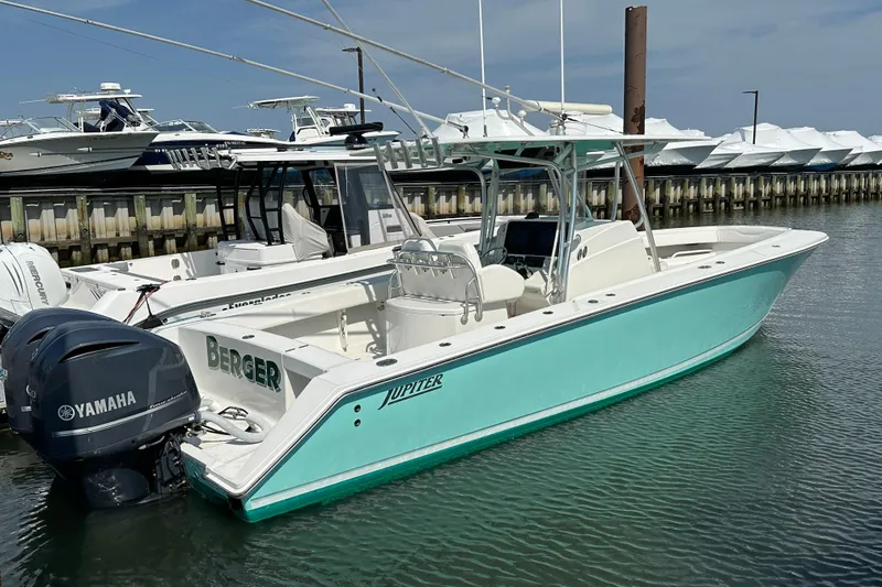 Slide: The Image of 2010 Jupiter 34 FS boat docked, featuring Yamaha engines, in a marina setting. - 59