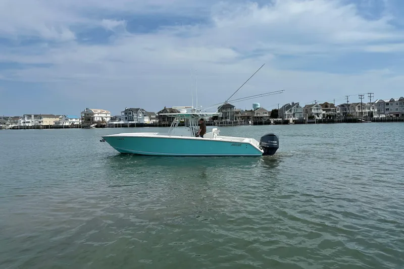 Slide: The Image of 2010 Jupiter 34 FS boat on calm water near coastal houses under a blue sky. - 9
