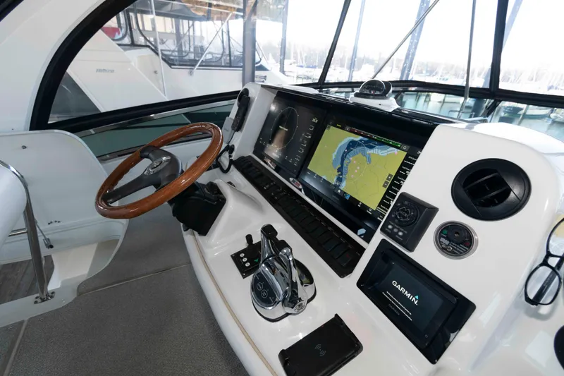 Slide: The Image of 2008 Sea Ray 52 Sedan Bridge helm with navigation display and wooden steering wheel. - 12