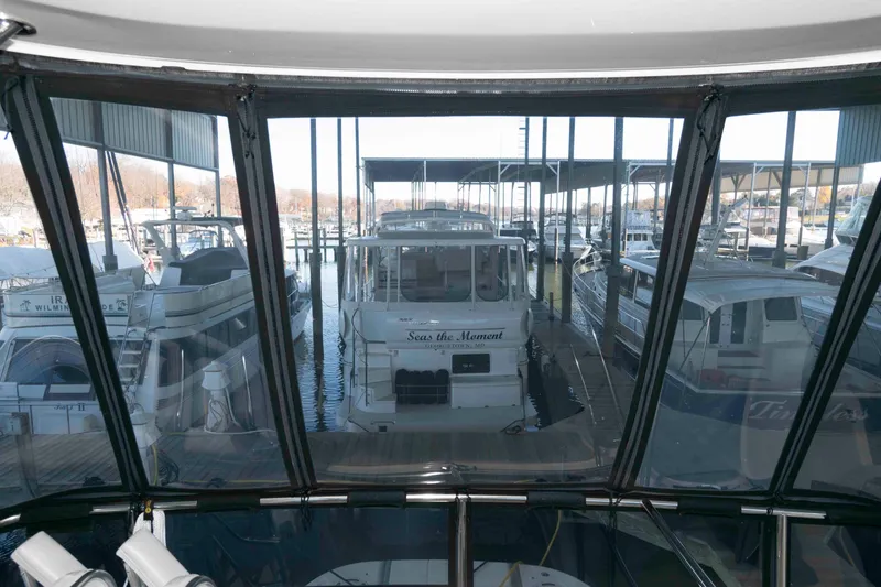 Slide: The Image of 2008 Sea Ray 52 Sedan Bridge yacht docked in a marina, viewed through a window. - 20