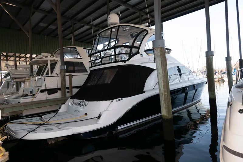 Slide: The Image of 2008 Sea Ray 52 Sedan Bridge yacht docked in a marina under a covered shelter. - 4
