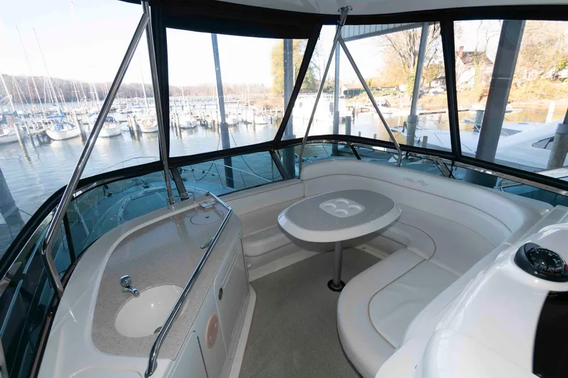 Slide: The Image of 2008 Sea Ray 52 Sedan Bridge interior with seating and table, overlooking marina. - 9
