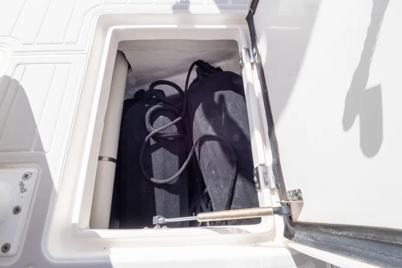 Slide: The Image of Storage compartment on 2015 Intrepid 400 Center Console boat, containing black bags. - 42