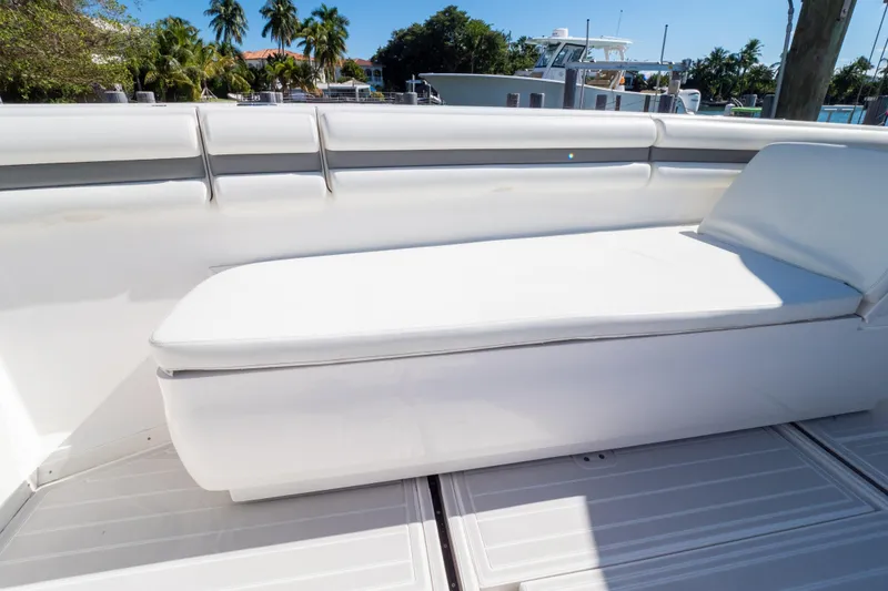 Slide: The Image of 2015 Intrepid 400 Center Console boat with white cushioned seating and tropical background. - 99
