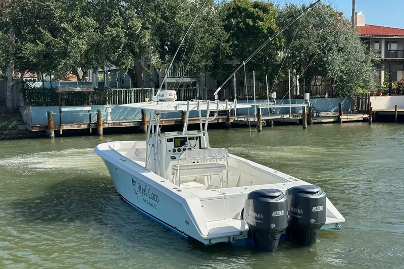 Slide: The Image of 2003 Venture 34 Center Console boat with dual Yamaha engines on a calm waterway. - 2
