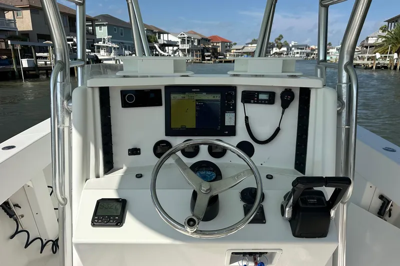 Slide: The Image of 2003 Venture 34 Center Console boat dashboard with navigation equipment and steering wheel. - 3