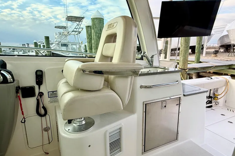 Slide: The Image of 2014 Boston Whaler 345 Conquest Pilothouse interior with captain's chair and control panel. - 15