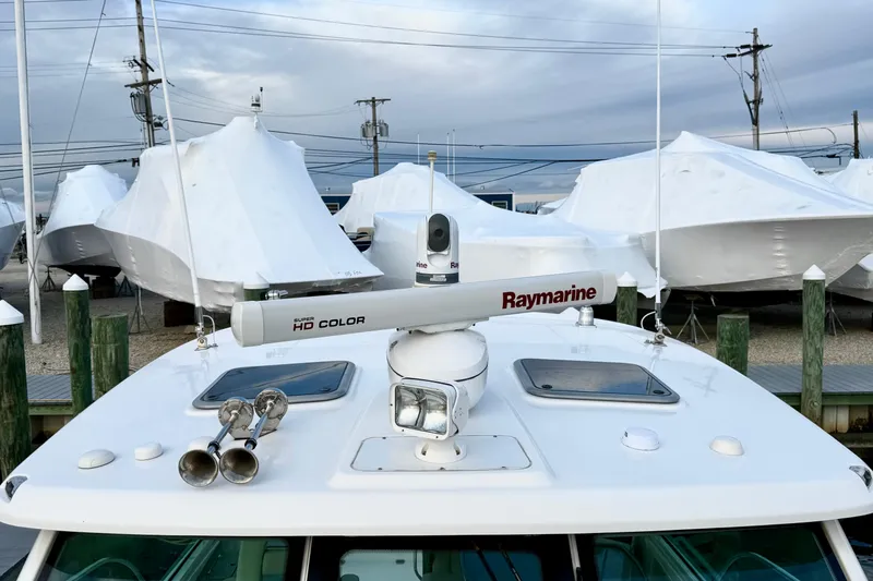 Slide: The Image of 2014 Boston Whaler 345 Conquest Pilothouse with Raymarine radar, docked among covered boats. - 25