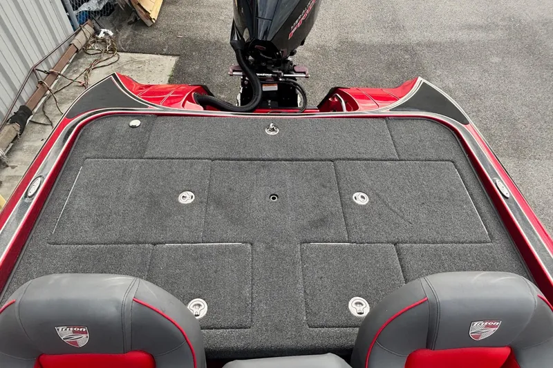 Slide: The Image of 2024 Triton 19 TrX Patriot boat interior with carpeted deck and dual seats. - 10