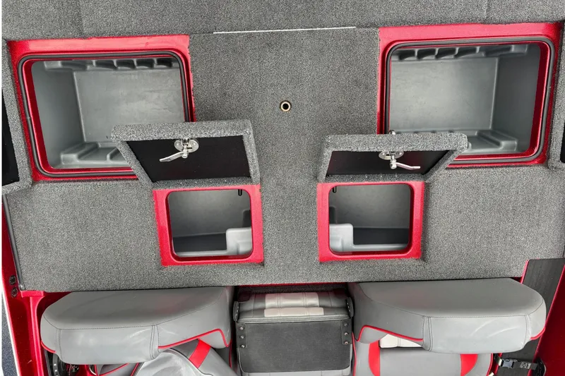 Slide: The Image of 2024 Triton 19 TrX Patriot boat storage compartments with gray and red interior. - 11