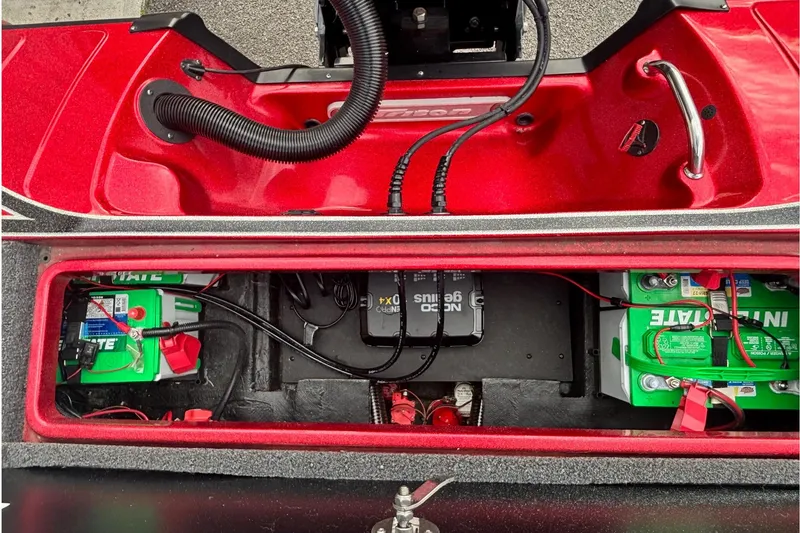 Slide: The Image of 2024 Triton 19 TrX Patriot boat battery compartment with wiring and components. - 12