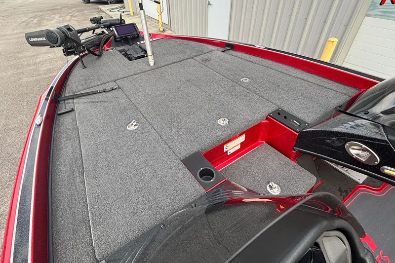 Slide: The Image of 2024 Triton 19 TrX Patriot boat deck with fishing equipment and storage compartments. - 4