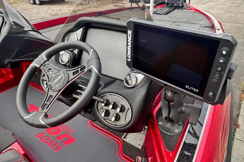 Slide: The Image of 2024 Triton 19 TrX Patriot boat dashboard with steering wheel and Lowrance Elite display. - 8