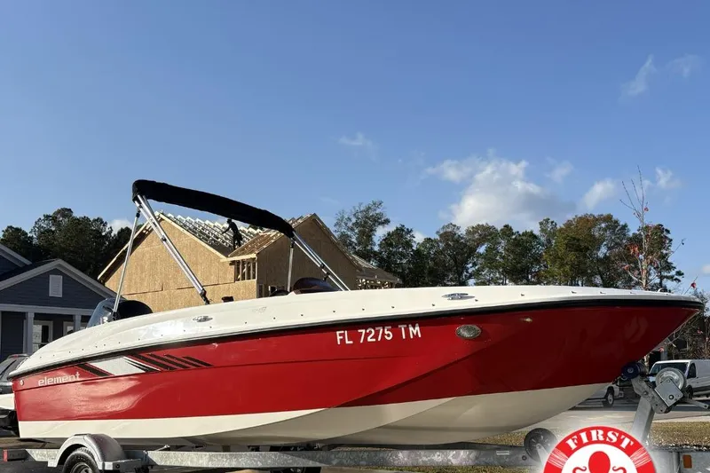 The Image of 2023 Bayliner Element E18 boat on trailer, red and white design, parked outdoors. - 1