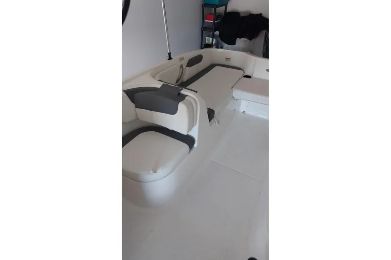 Slide: The Image of 2023 Bayliner Element E18 boat interior with white and gray seating. - 13