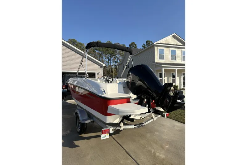 Slide: The Image of 2023 Bayliner Element E18 boat with outboard motor parked in driveway. - 5