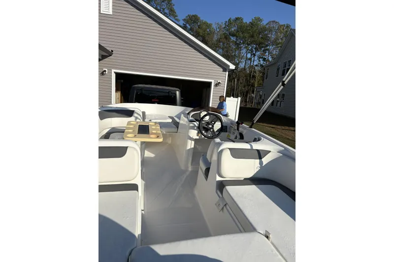 Slide: The Image of 2023 Bayliner Element E18 boat interior with steering wheel and seating. - 6