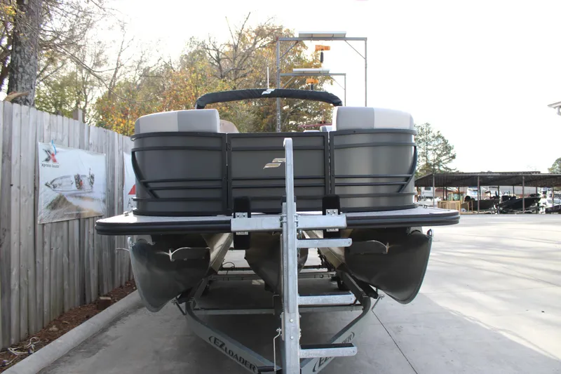 Slide: The Image of 2026 Starcraft EXS 3 Q pontoon boat on trailer, parked outdoors. - 3