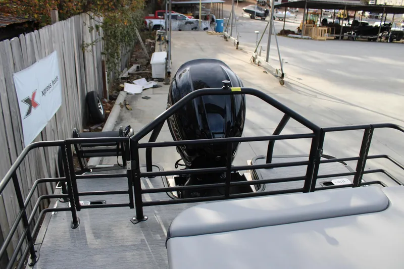 Slide: The Image of 2026 Starcraft EXS 3 Q boat rear view with motor, docked near a wooden fence. - 9