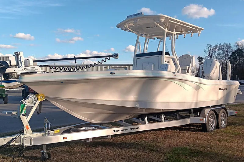 Slide: The Image of 2026 Ranger 2660 Bay boat on trailer, parked outdoors under a clear sky. - 3