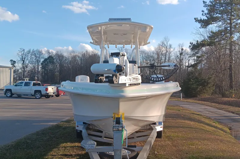 Slide: The Image of 2026 Ranger 2660 Bay boat on trailer, parked outdoors with trees and vehicles nearby. - 5