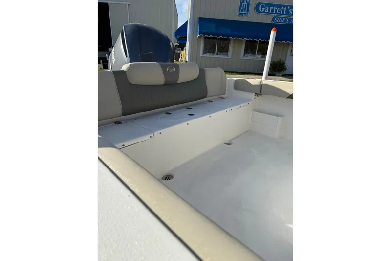 Slide: The Image of 2026 Key West 239 FS boat interior with seating and engine, docked near Garrett's Ship Store. - 4