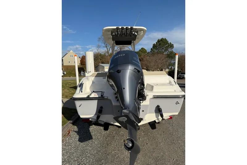 Slide: The Image of 2026 Key West 239 FS boat with powerful outboard motor, parked on gravel driveway. - 6
