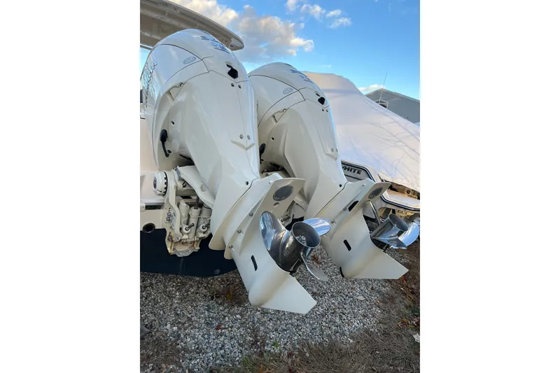 Slide: The Image of 2024 Grady-White Freedom 285 boat with dual outboard engines on gravel. - 3