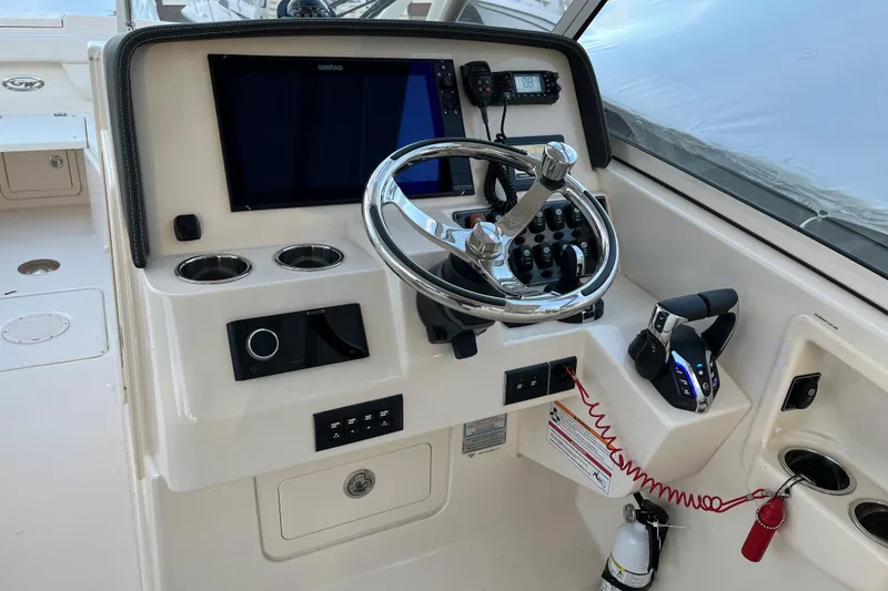 Slide: The Image of 2024 Grady-White Freedom 285 helm with steering wheel, controls, and navigation display. - 4