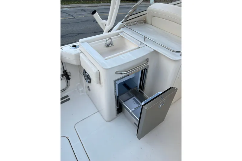 Slide: The Image of 2024 Grady-White Freedom 285 boat interior with open storage compartment and sink. - 8