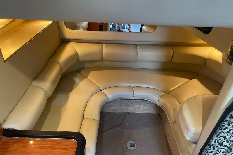 Slide: The Image of 1999 Sea Ray 370 Sundancer interior with beige leather seating and cozy cabin layout. - 19