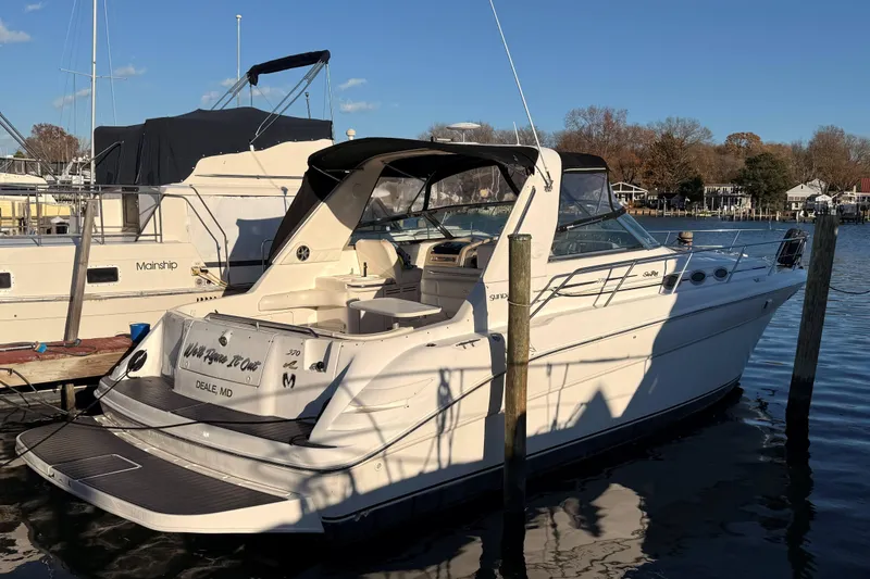 Slide: The Image of 1999 Sea Ray 370 Sundancer yacht docked at marina under clear blue sky. - 5