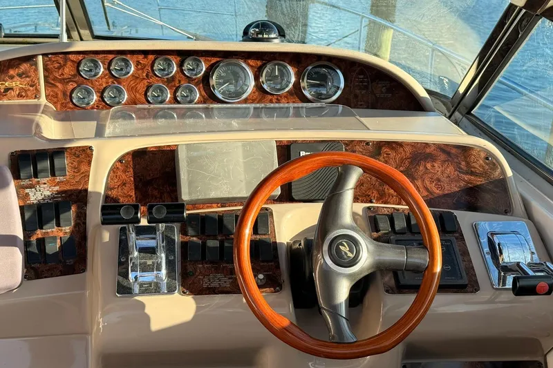 Slide: The Image of 1999 Sea Ray 370 Sundancer docked, featuring a sleek swim platform and black cover. - 6