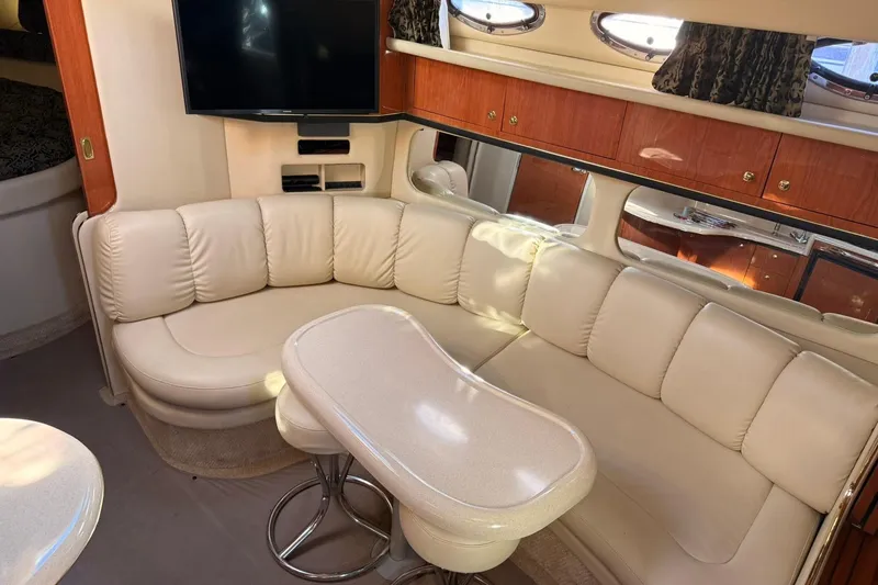 Slide: The Image of 1999 Sea Ray 370 Sundancer helm with steering wheel, gauges, and white seating. - 9