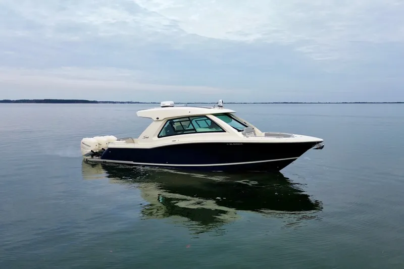 The Image of 2023 Scout 350 LXZ boat cruising on calm waters under a cloudy sky. - 0