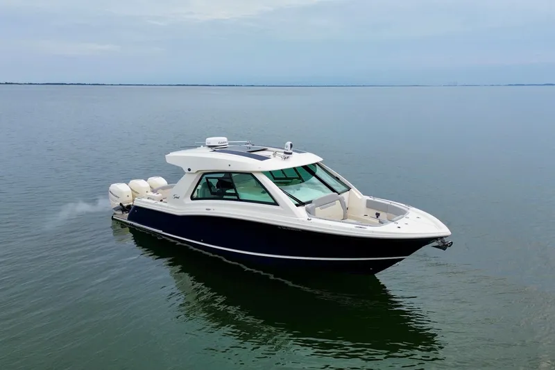 Slide: The Image of 2023 Scout 350 LXZ boat cruising on calm waters. - 10