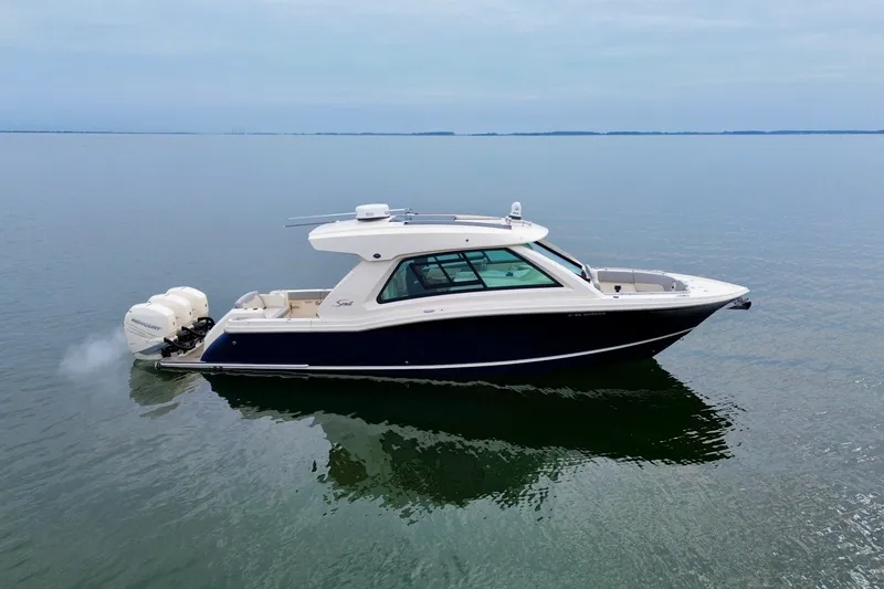 Slide: The Image of 2023 Scout 350 LXZ boat cruising on calm waters. - 11