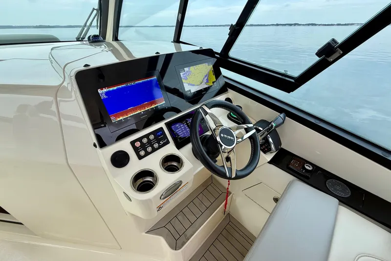 Slide: The Image of 2023 Scout 350 LXZ boat helm with advanced navigation displays and steering wheel. - 17