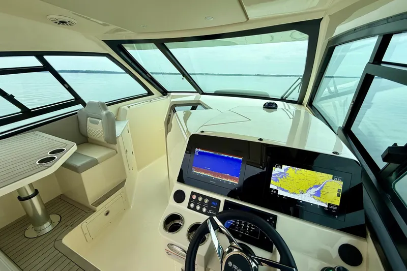 Slide: The Image of 2023 Scout 350 LXZ boat interior with navigation screens and seating area. - 18