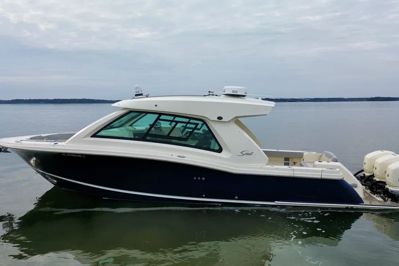 Slide: The Image of 2023 Scout 350 LXZ boat on calm water, side view. - 2