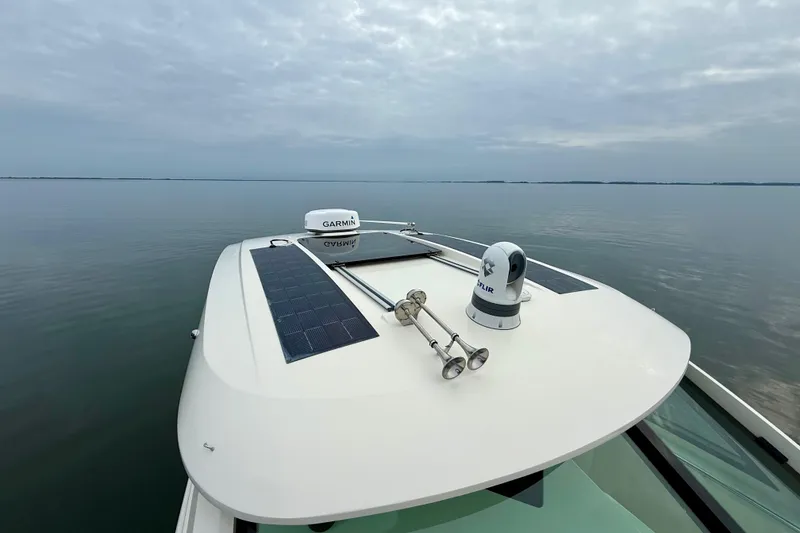 Slide: The Image of 2023 Scout 350 LXZ boat with solar panels and navigation equipment on calm water. - 30