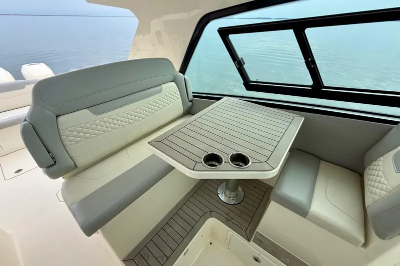 Slide: The Image of 2023 Scout 350 LXZ boat interior with elegant seating and table by the window. - 33