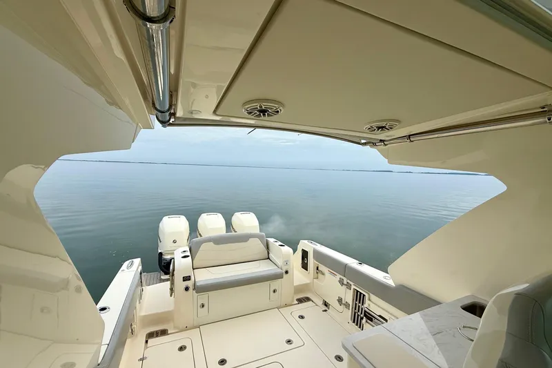 Slide: The Image of 2023 Scout 350 LXZ boat interior with triple engines on calm water. - 38