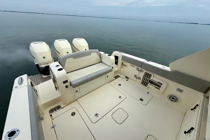 Slide: The Image of 2023 Scout 350 LXZ boat with triple outboard engines on calm water. - 43