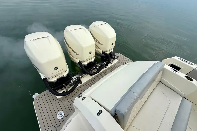 Slide: The Image of 2023 Scout 350 LXZ boat with triple Mercury outboard engines on calm water. - 48