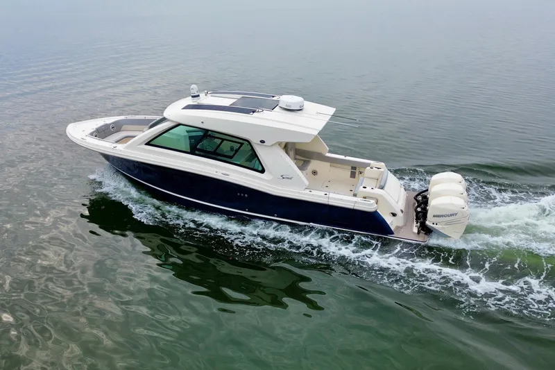 Slide: The Image of 2023 Scout 350 LXZ boat cruising on calm water, featuring sleek design and powerful engines. - 5
