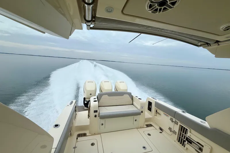 Slide: The Image of 2023 Scout 350 LXZ boat cruising on calm waters, showcasing powerful engines and sleek design. - 50
