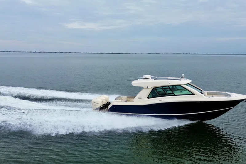 Slide: The Image of 2023 Scout 350 LXZ boat cruising on open water, showcasing sleek design and powerful engines. - 6