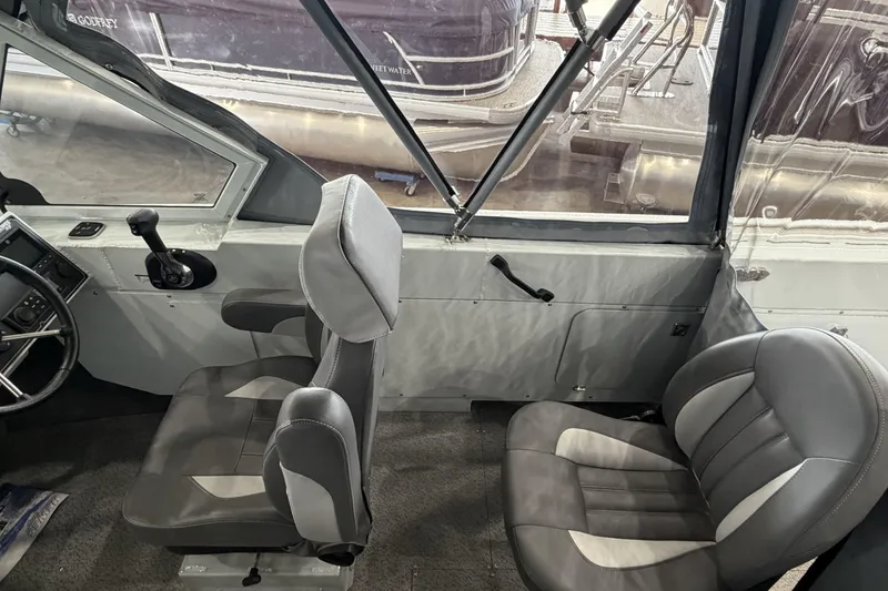 Slide: The Image of Interior of 2026 Hewescraft 221 Evolution boat with gray seating and steering controls. - 12